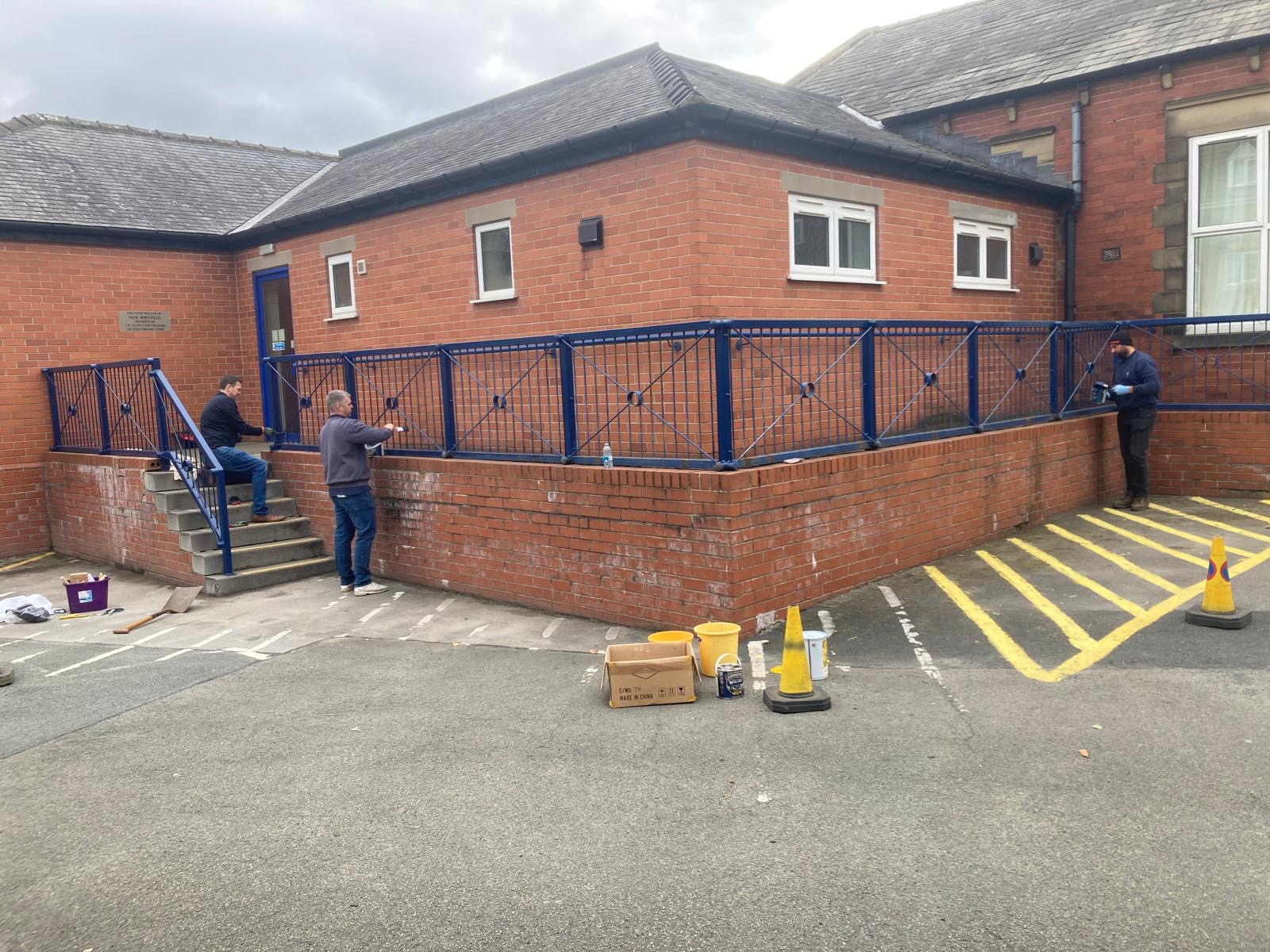 Image of the team painting the blue railings